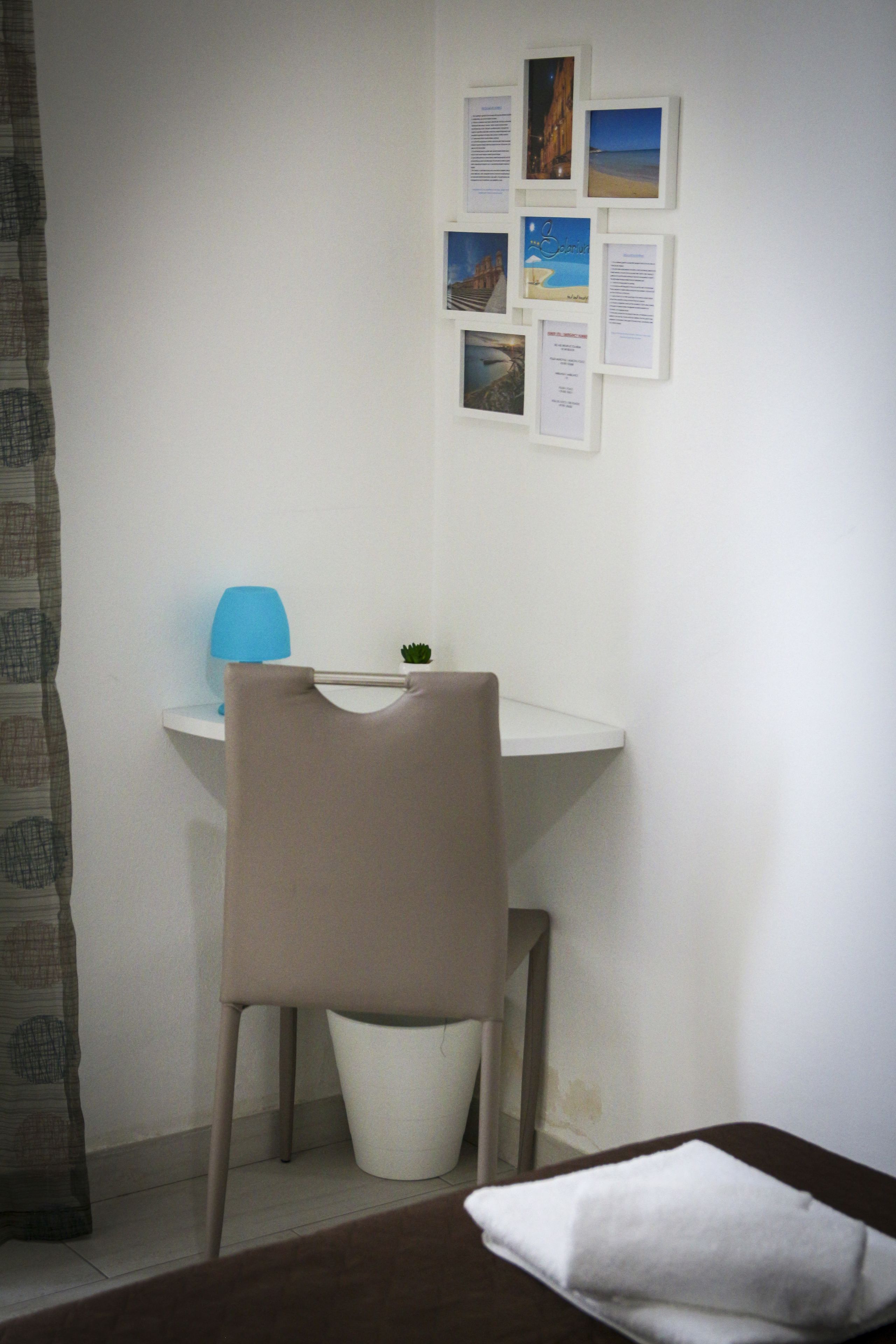 Un espacio de trabajo pequeño y ordenado con escritorio, silla y una planta pequeña.