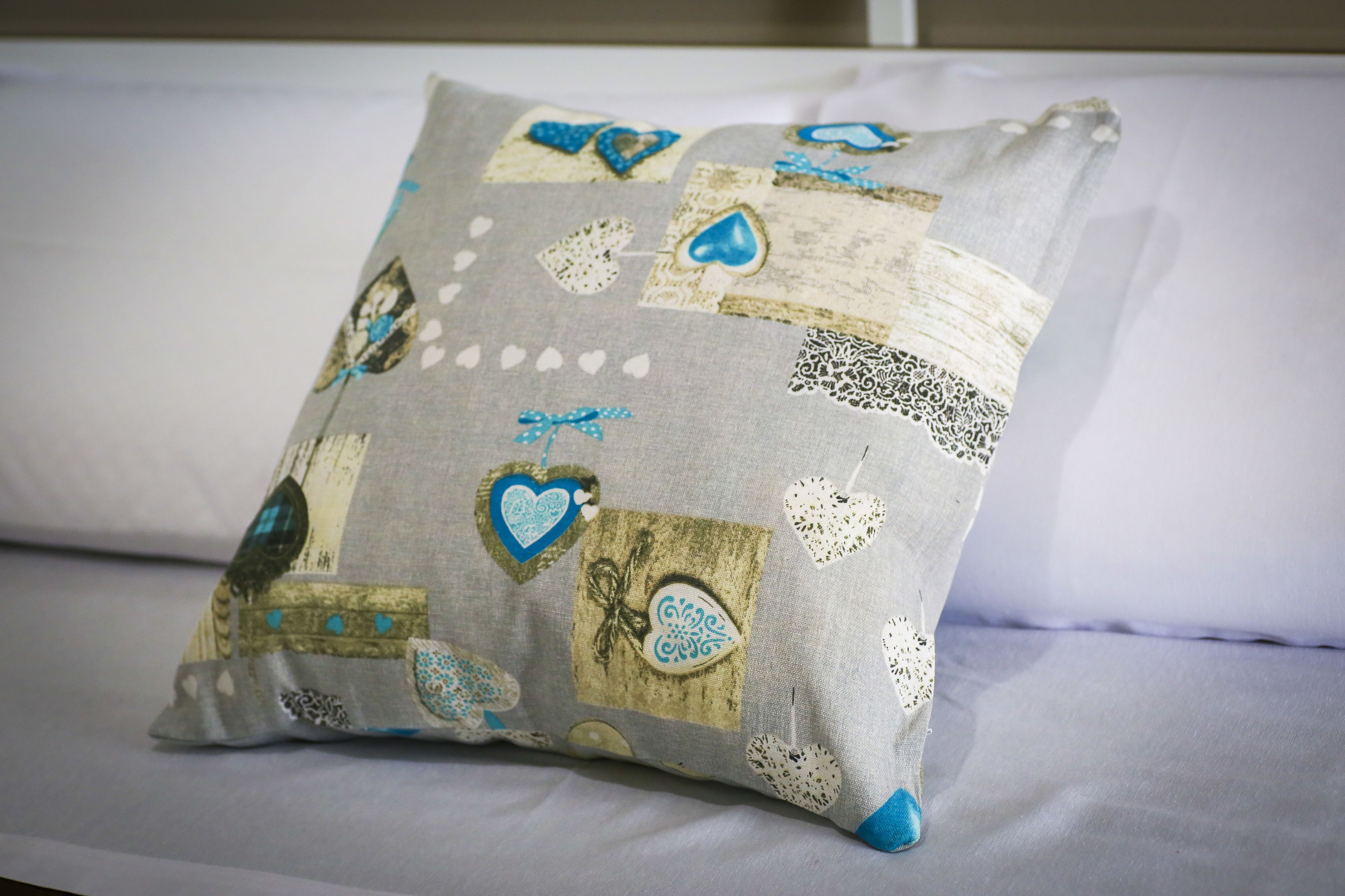 A pillow with a patchwork design on a bed.