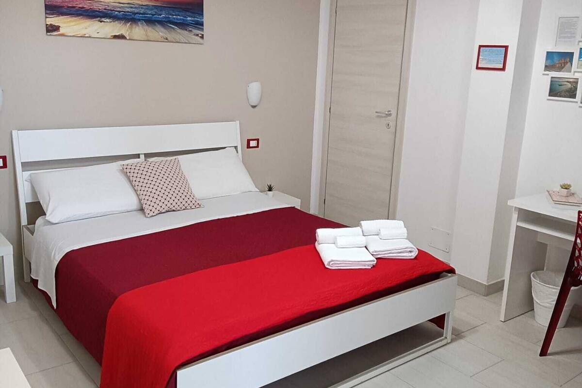 Ein ordentlich eingerichtetes Schlafzimmer mit Bett, Schreibtisch und Stuhl.