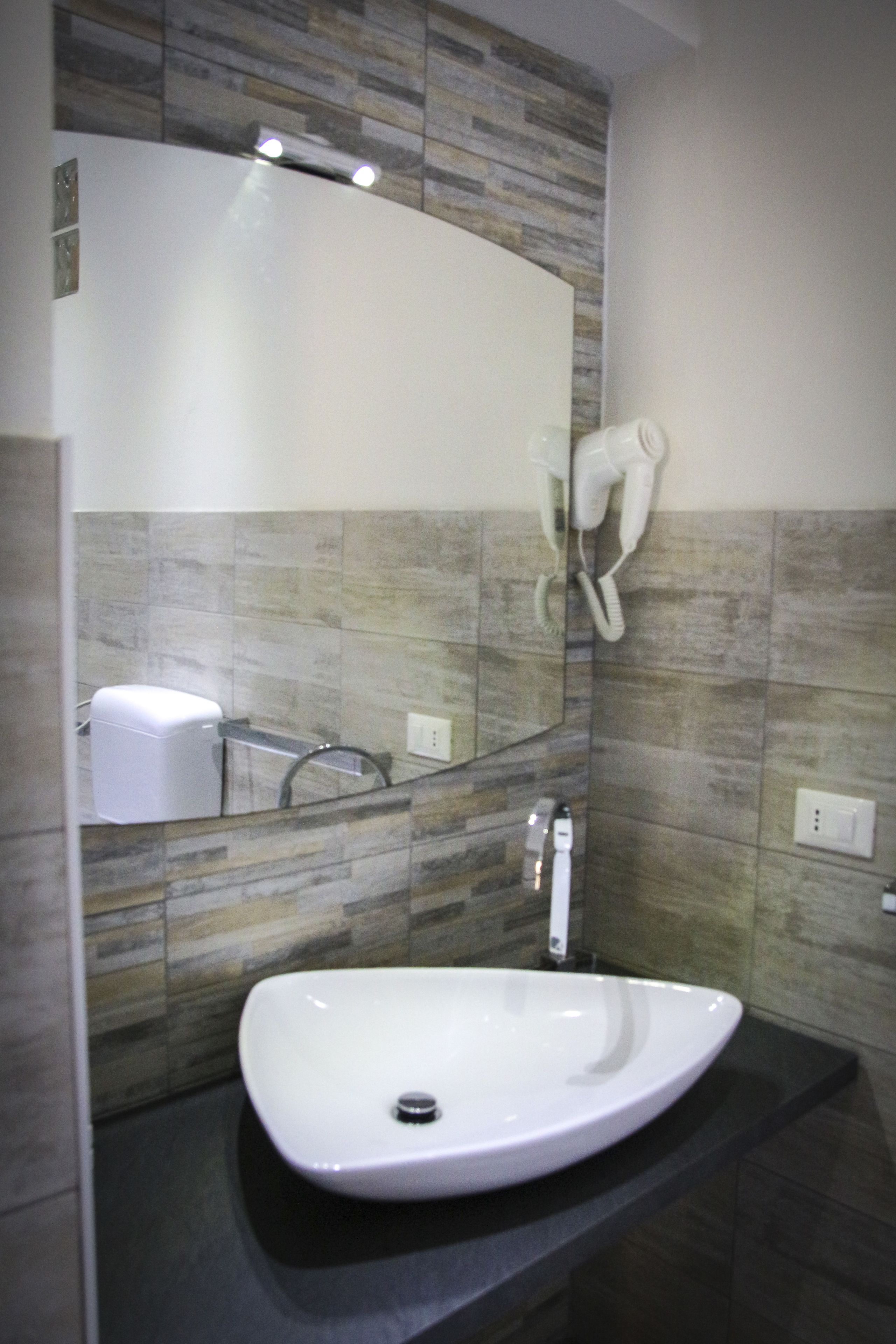 A bathroom with a white sink, a large mirror, and a towel rack.