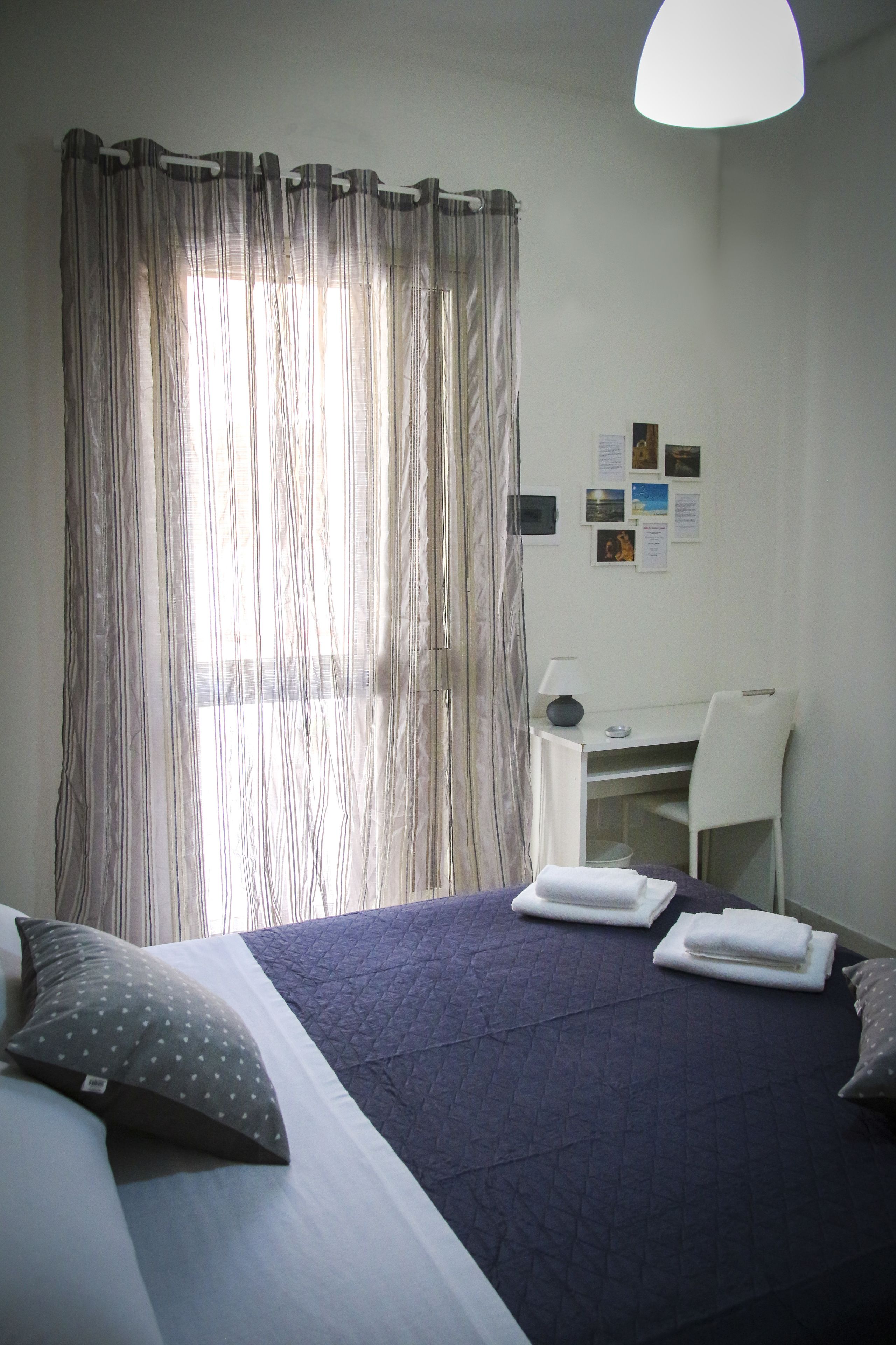 A hotel room with a bed, a desk, and a chair.