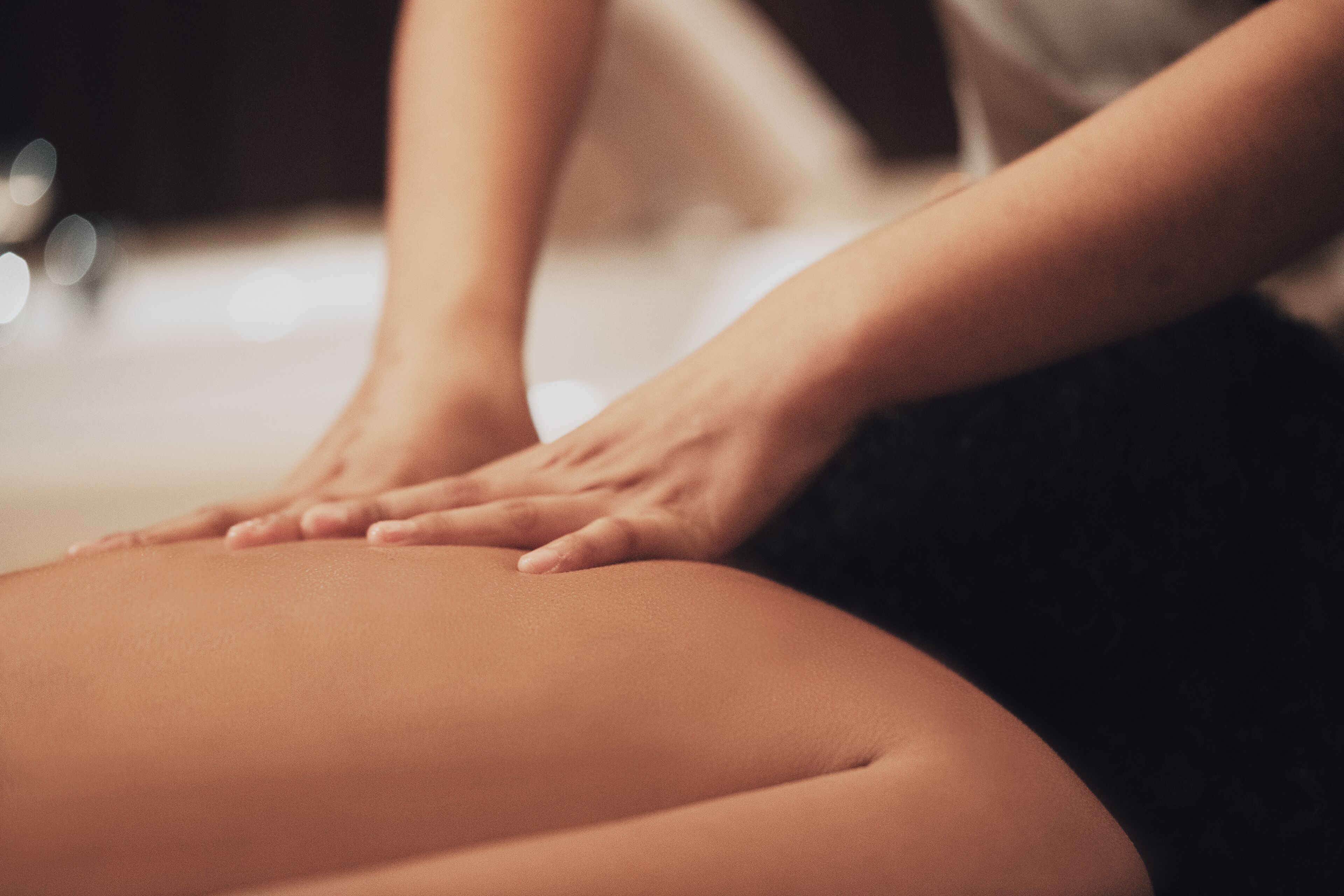 A close-up of hands performing a massage on a person's back.