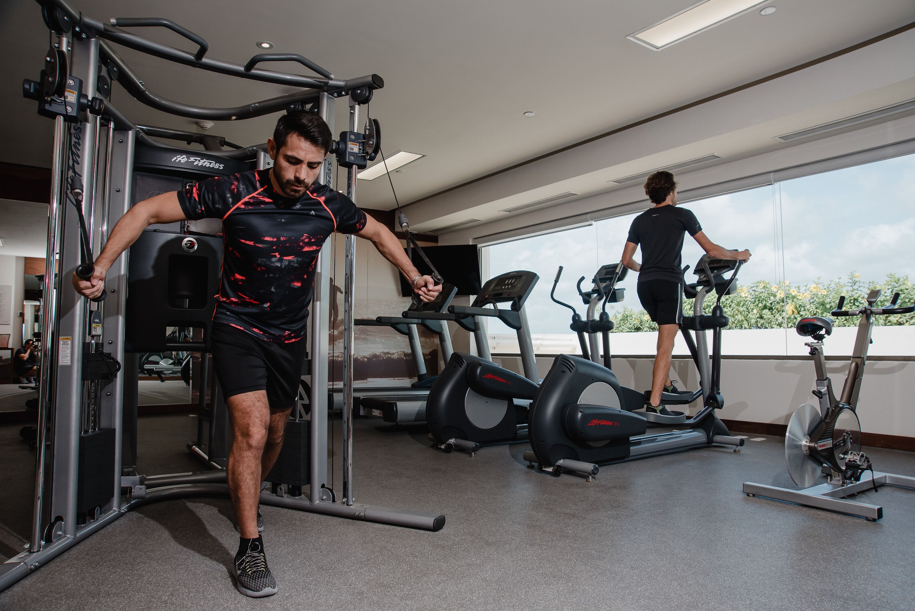 A gym with exercise equipment, including a weight machine and treadmills.