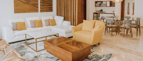 A modern living room with a white sofa, yellow armchair, and a wooden coffee table.