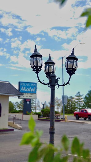 Un lampadaire à trois globes, une enseigne de motel et, au fond, un camion rouge.