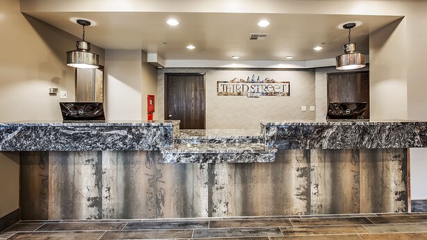 A reception area with a marble counter, two pendant lights, and a sign reading "THIRD STREET INN". - Third Street Inn (McCall)