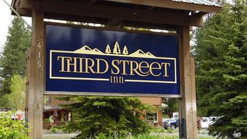 Une enseigne pour le Third Street Inn, avec un logo représentant la silhouette d’une montagne et le nom de l’établissement.