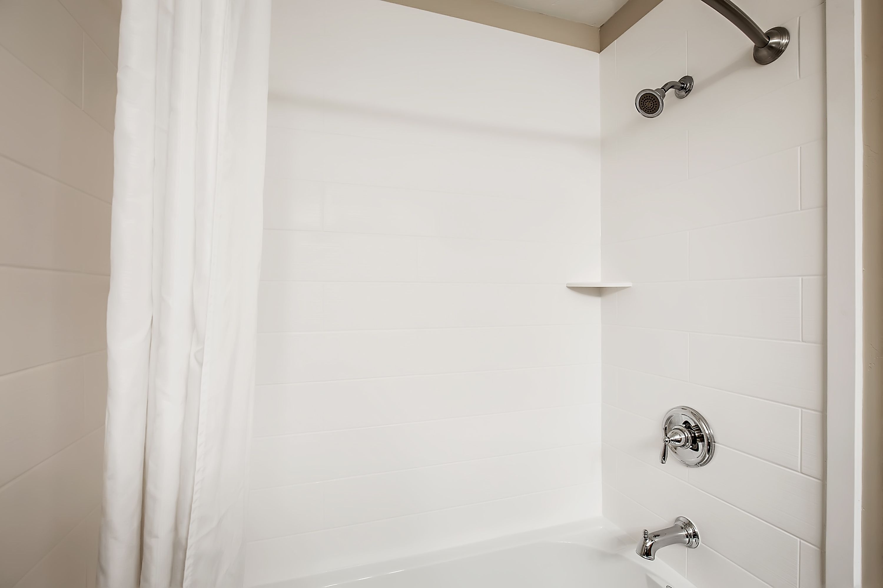 A white bathroom with a shower, a bathtub, and a toilet.