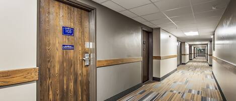 A hallway with a wooden door labeled "103" and "Lighthouse Street," leading to a room.