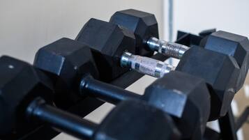 A set of black dumbbells on a rack.