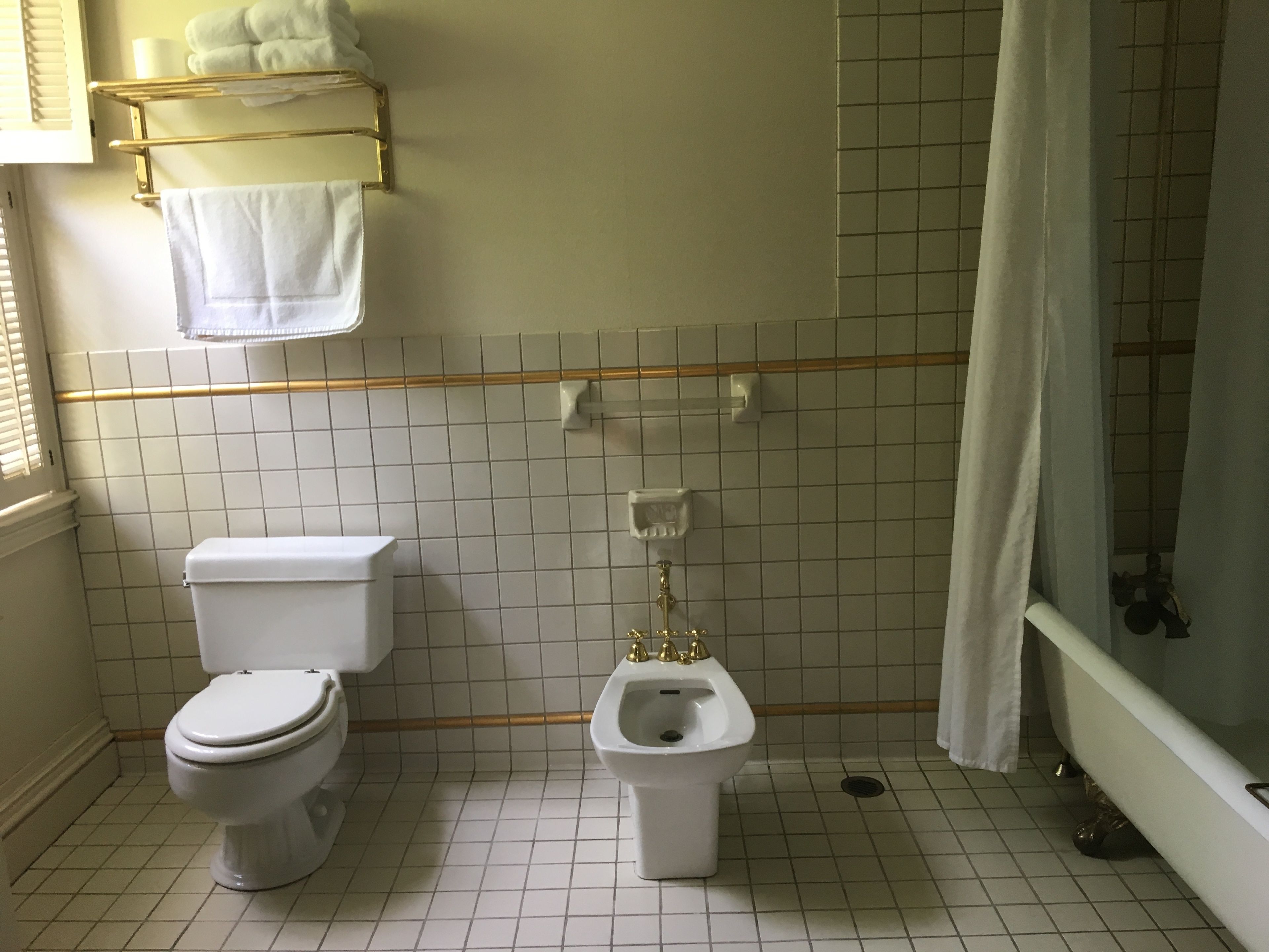 A bathroom with a toilet, bidet, and bathtub.