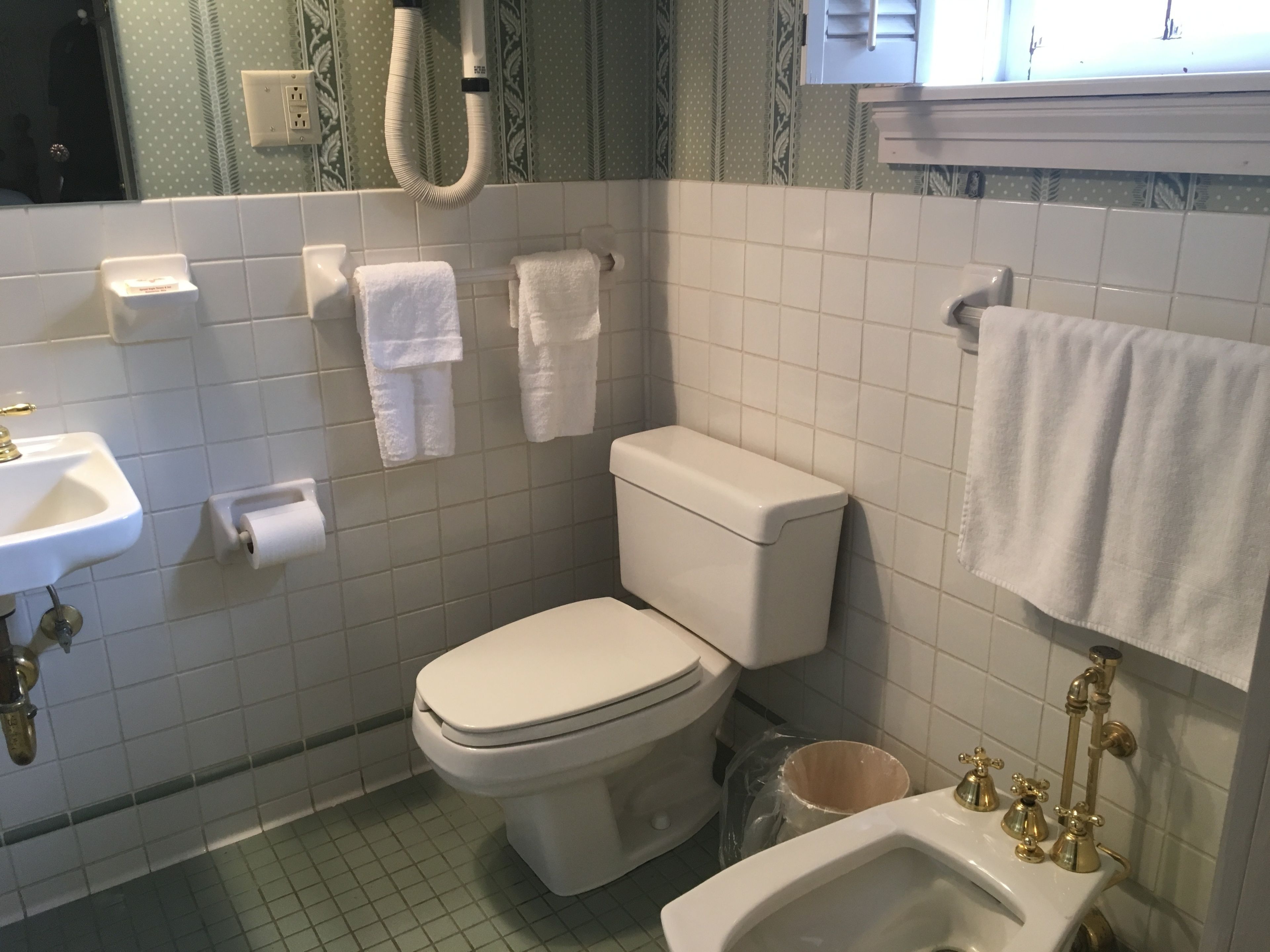 A bathroom with a toilet, sink, and shower.