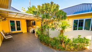 A covered patio area with a seating arrangement and a small garden. - Platinum 3 bedrooms villa pool garden (Rawai)