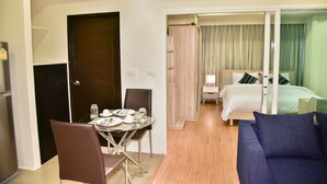 A hotel room with a dining area, a bed, and a sofa. - The Kaze 34 Hotel and Serviced Residence (Bangkok)