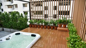 A rooftop terrace with a hot tub, potted plants, and a wooden fence. - The Kaze 34 Hotel and Serviced Residence (Bangkok)