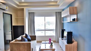 A modern living room with a sofa, coffee table, and TV stand.
