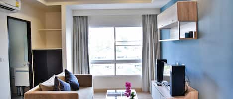 Una sala de estar moderna con un sofá, una mesa de centro y un mueble para televisión.