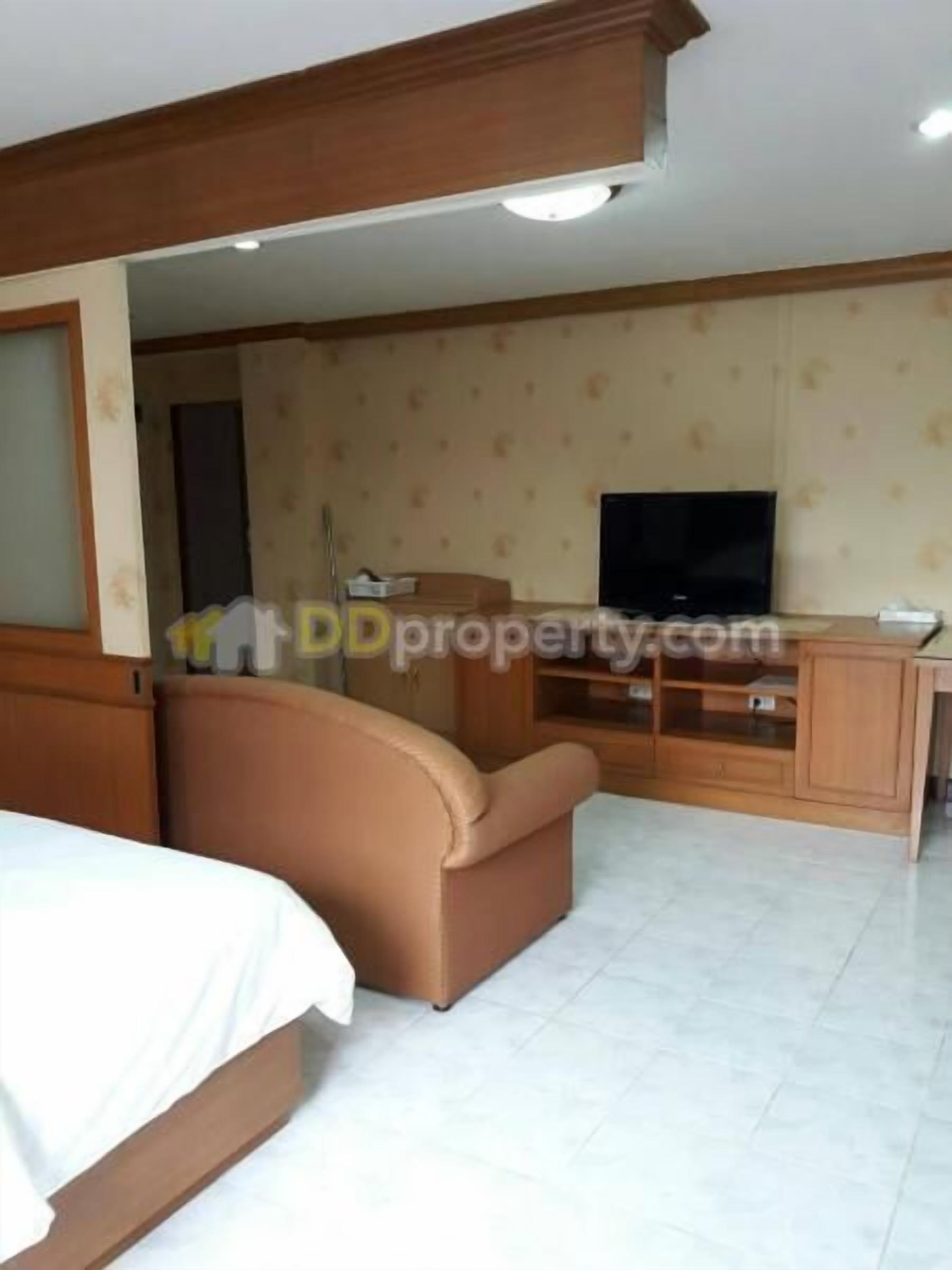 A hotel room with a bed, a sofa, a TV, and a desk.