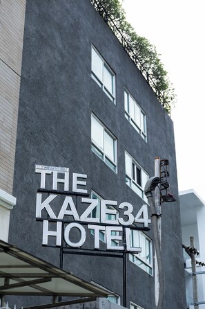 A building with a sign that reads 'The Kaze34 Hotel' indicating the name of the establishment.