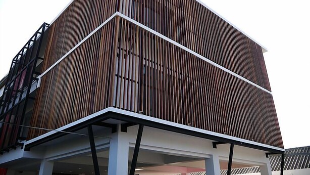 Un edificio moderno con una fachada de madera llamativa y techo plano.