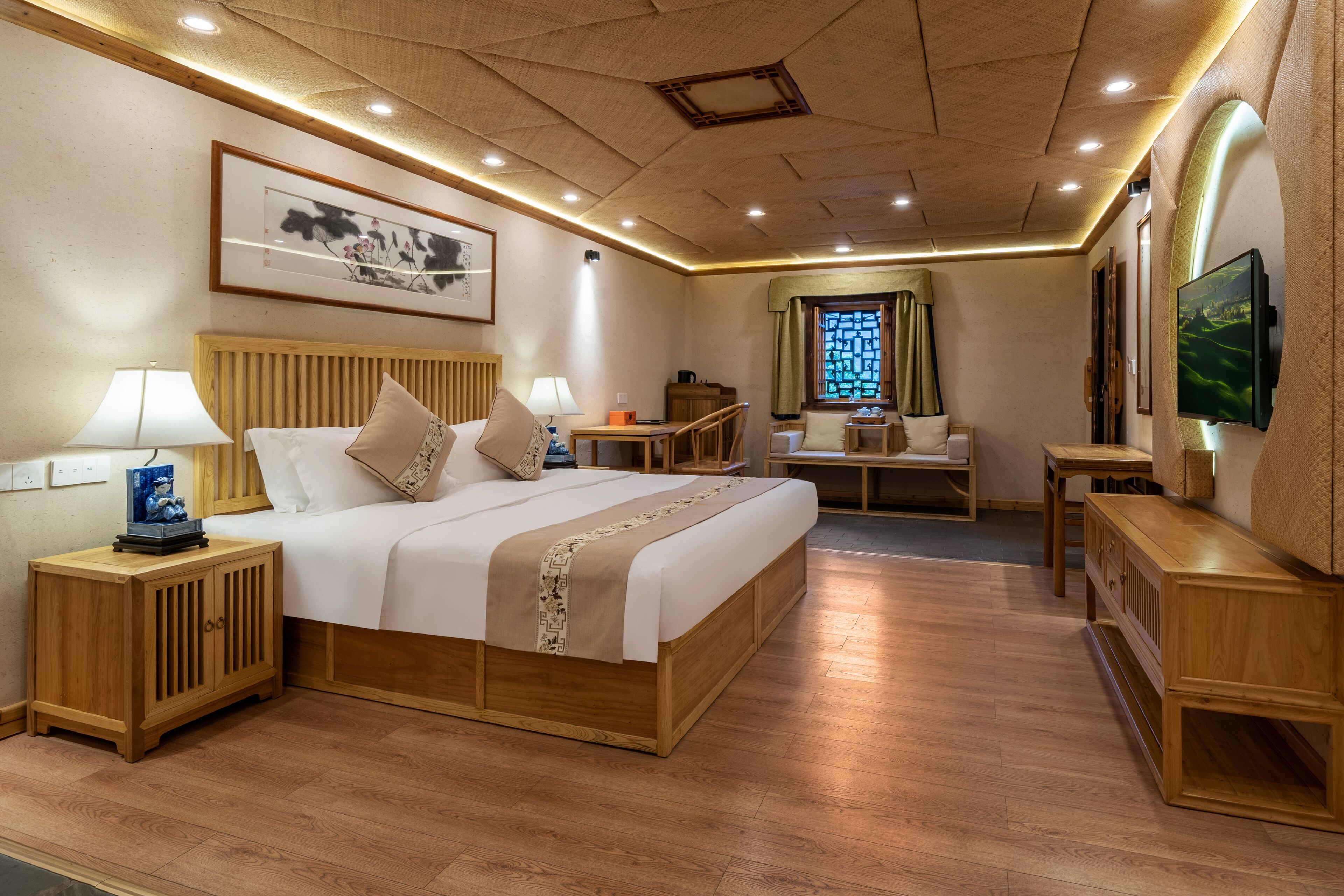 A hotel room with a wooden bed, bedside tables, a desk, and a TV.