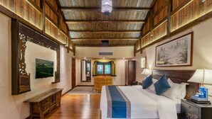 A spacious room with a large bed, wooden flooring, and a high ceiling with exposed beams. - Yangshuo Ancient Garden Boutique Hotel (Guilin)