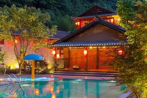 Una piscina al aire libre, sillones reclinables de piscina