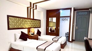 A hotel room with two beds, a large mirror, a wardrobe, and a door with a hanging rack. - Leelawadee Resotel Raminthra 23 (Bangkok)