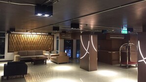 A modern lobby with a sofa, chairs, and a reception desk. - Leelawadee Resotel Raminthra 23 (Bangkok)