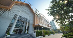 Un bâtiment moderne doté d’une entrée imposante, de grandes fenêtres en verre et d’une façade métallique.
