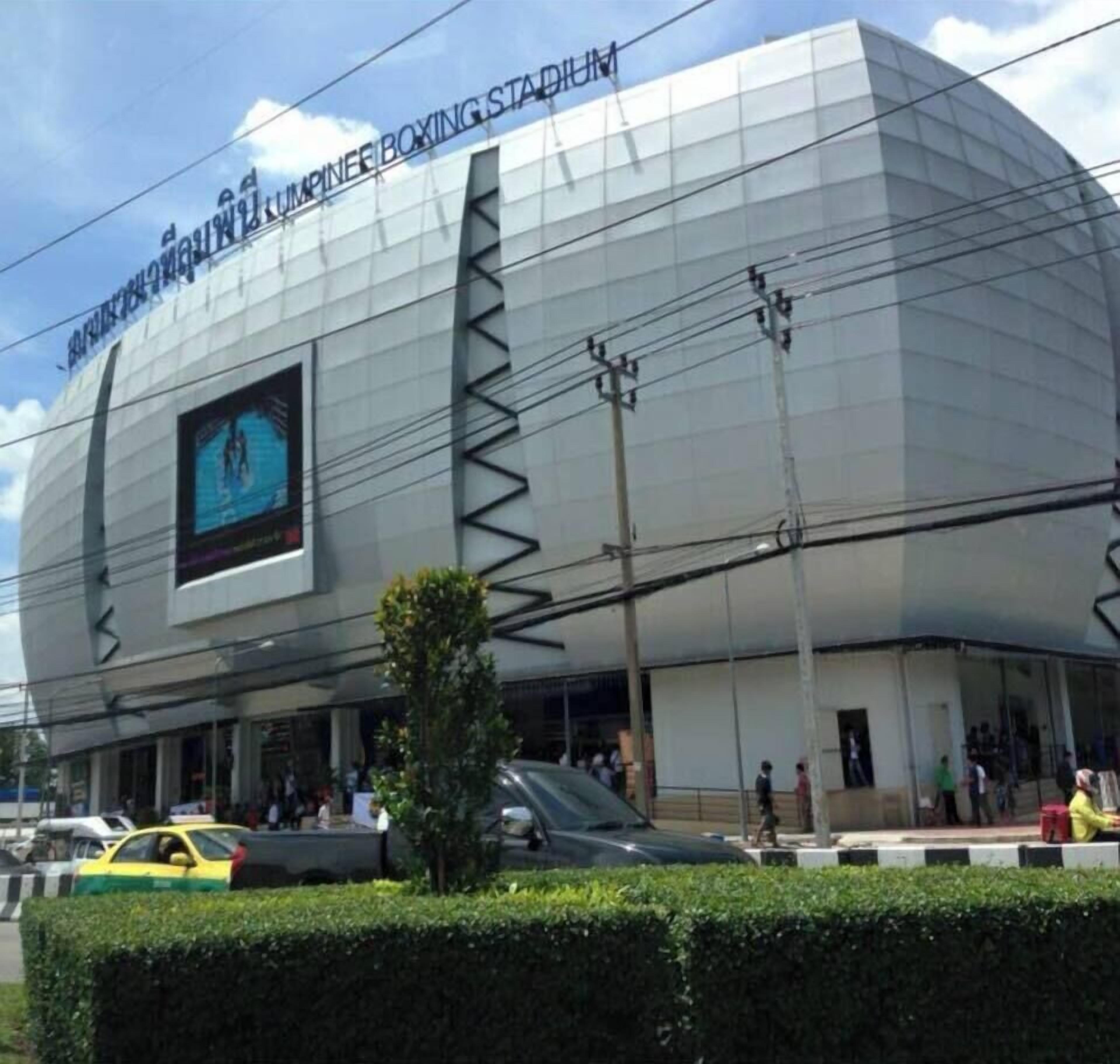 Un bâtiment moderne doté d’un grand écran numérique et d’une enseigne indiquant « STADE DE BOXE JUMPIER ».