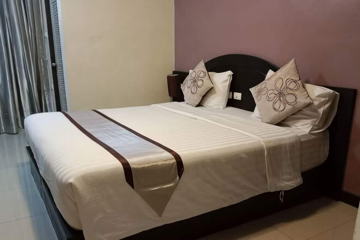 A bed with a headboard, two pillows with floral designs, and a brown decorative strip.