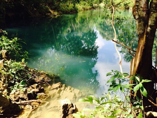 A natural water body surrounded by rocks and vegetation. - Pandan Beach Resort (Pandan)