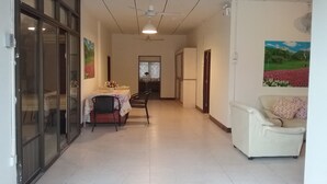 Un pasillo con comedor, sofá y refrigerador.
