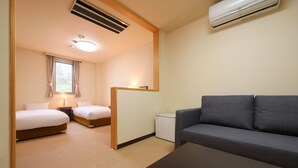 A hotel room with two beds, a sofa, a small table, and a desk. - Matsushima Hotel Waraku (Matsushima)