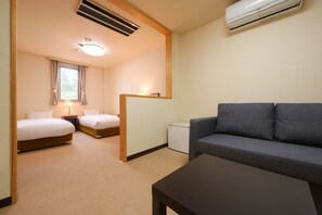 A hotel room with two beds, a sofa, a small table, and a desk. - Matsushima Hotel Waraku (Matsushima)
