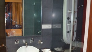 A modern bathroom with a white sink, a glass-enclosed shower, and a mirror above the sink. - The Horizon Comforts (Bengaluru)