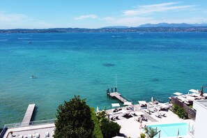 Ein Hotel an der Küste mit Pool, Sitzgelegenheiten im Freien und Meerblick.