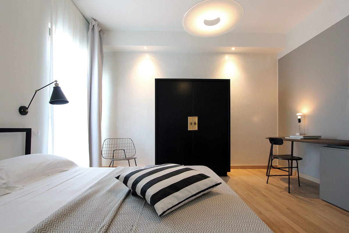 Een moderne hotelkamer met een bed, een bureau en een stoel.