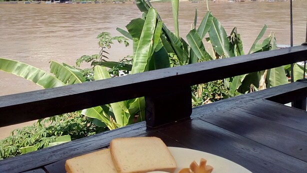 A meal on a table with a view of a river and hills in the background. - Sokmisay Hotel・GuestHouse (Luang Prabang)