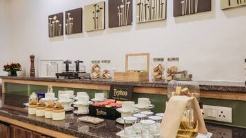 A breakfast buffet with various food items, coffee, and tea options.