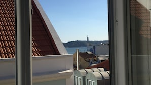 A view from a window overlooking a coastal area with buildings and a church steeple. - 54 Santa Catarina Boutique Aparthotel (Lisbon)