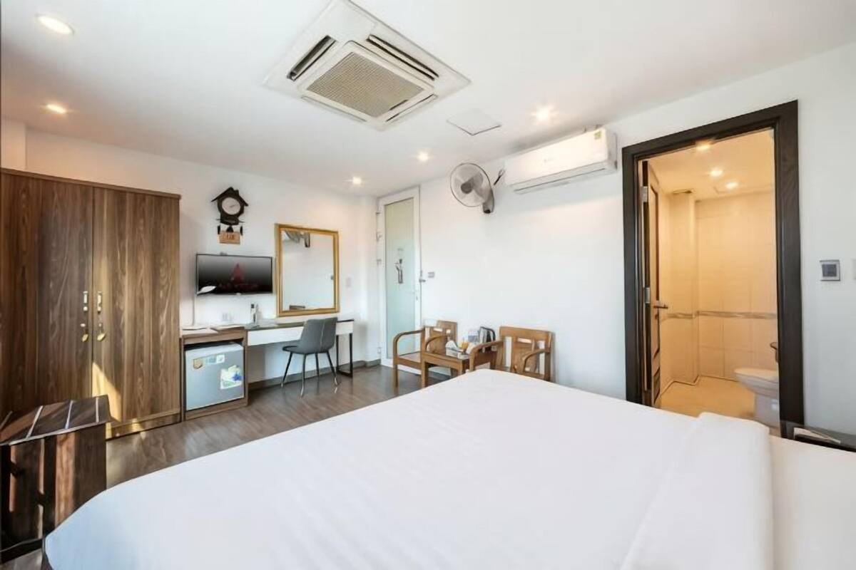 Une chambre d’hôtel équipée d’un lit, d’un bureau, d’une chaise, d’une armoire et d’un espace douche.