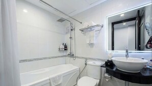 Uma casa de banho moderna com banheira, sanita e lavatório.
