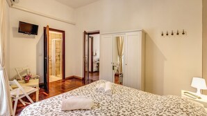 Une chambre d’hôtel équipée d’un lit, d’un bureau, d’une chaise, d’une télévision et d’une armoire.
