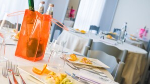 A dining table set with plates, cutlery, and a clear glass pitcher. - Hotel Metropol (Senigallia)
