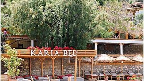 A wooden deck with lounge chairs and a sign reading "KARIA BEI". - Karia Bel Hotel & Restaurant - Adults Only (Marmaris)