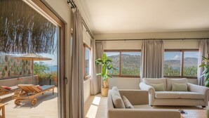 A spacious living area with a large window, a sofa, a coffee table, and a sun lounger. - Karia Bel Hotel & Restaurant - Adults Only (Marmaris)