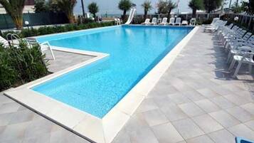 Alberca al aire libre por temporada y sombrillas en la alberca