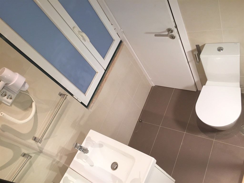 A bathroom with a toilet, sink, and shower.